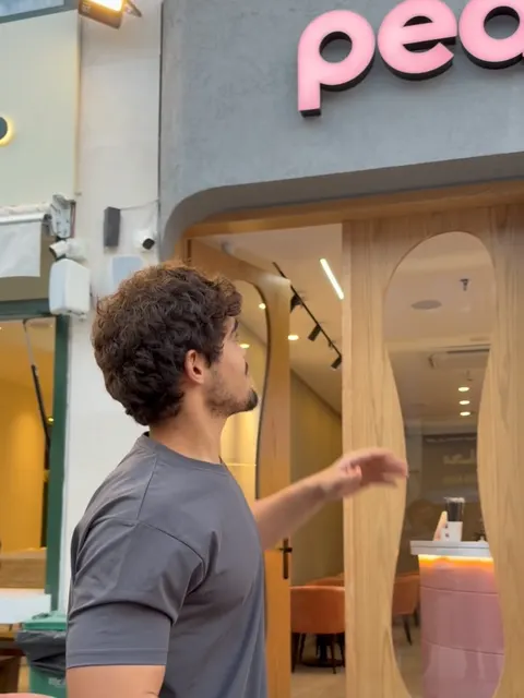 The peak storefront by day: the pink sign over the wavy wooden door, and the pink counter inside.